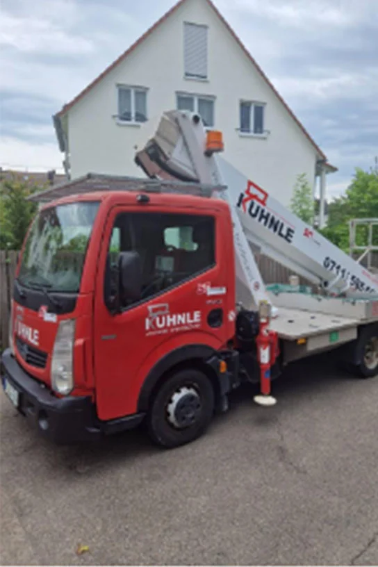 Arbeitsbühne vor weißem Haus geparkt.