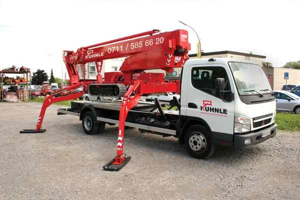 Rote Arbeitsbühne, hinten geparkte Fahrzeuge, Arbeitszubehör und Gebäude.