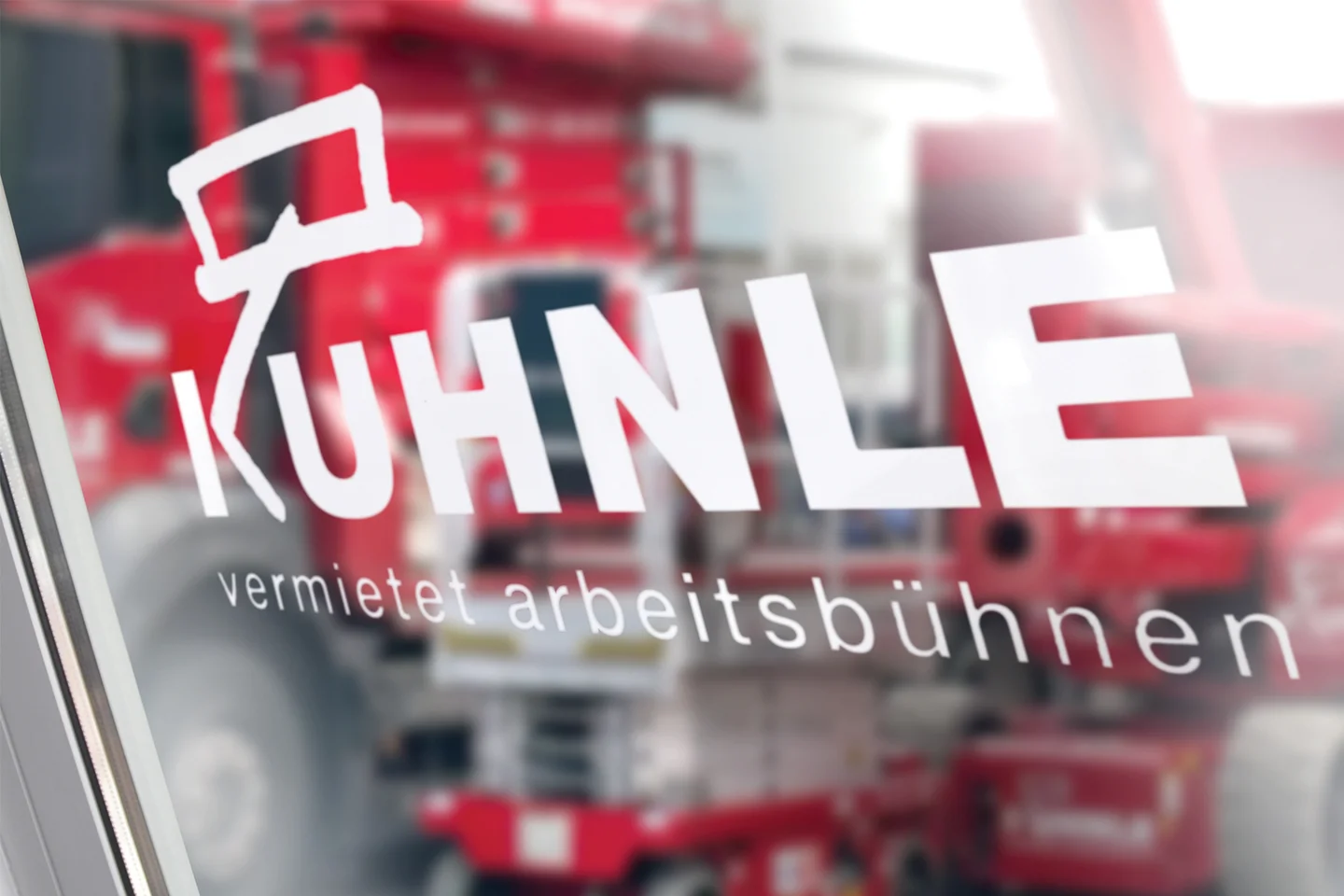 Kuhnle Logo auf Glastür, dahinter Arbeitsbühnen