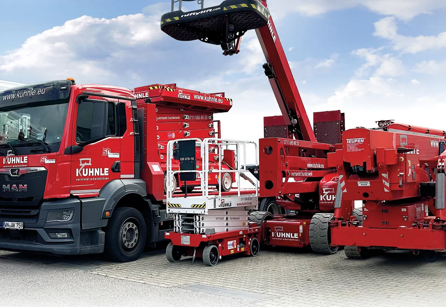 Drei rote Arbeitsbühnen nebeneinander geparkt, blauer Himmel mit Wolken im Hintergrund.